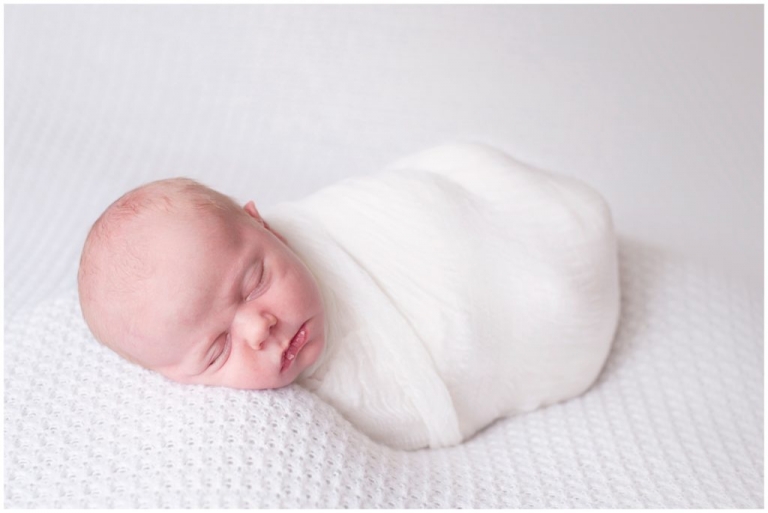 Pittsburgh wrapped posed newborn white backdrop